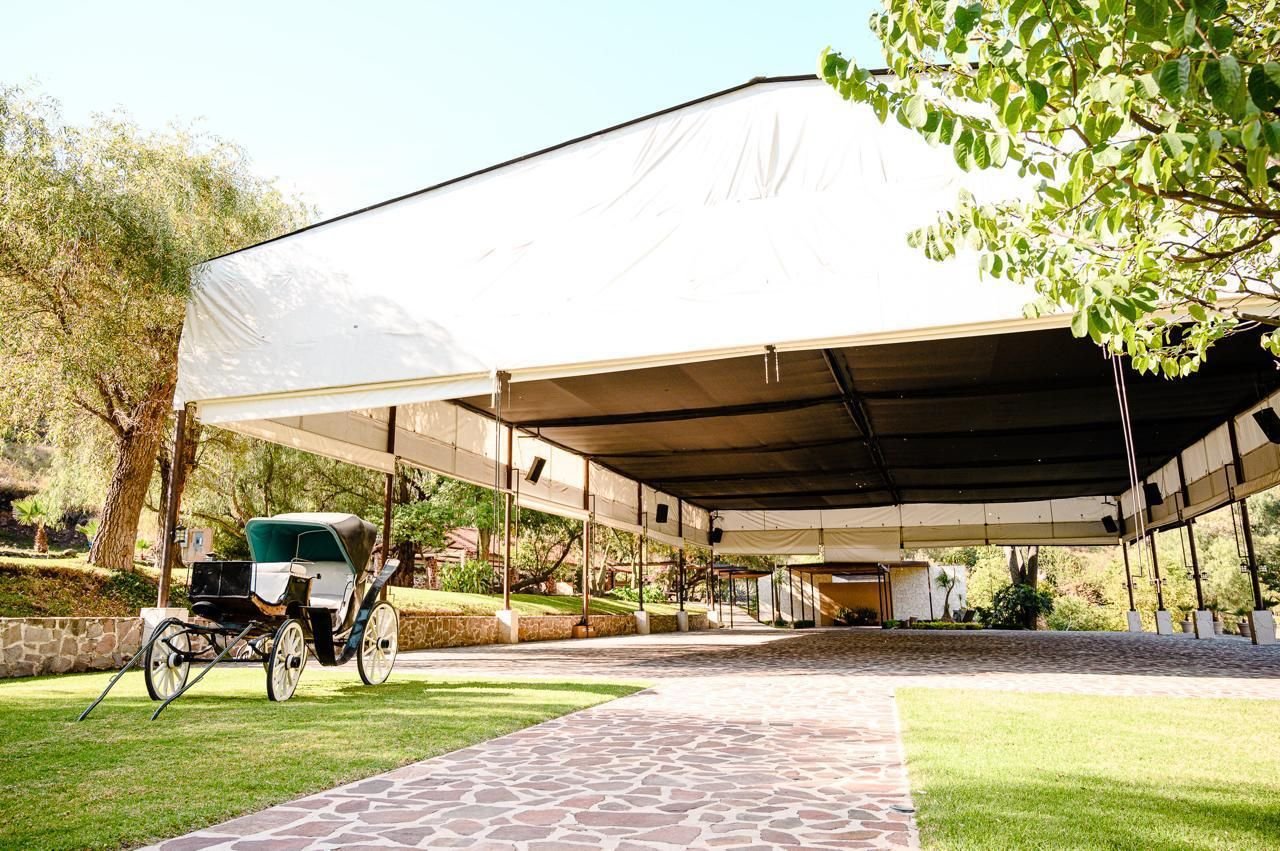 Carpa con carruaje antiguo y andador de piedra