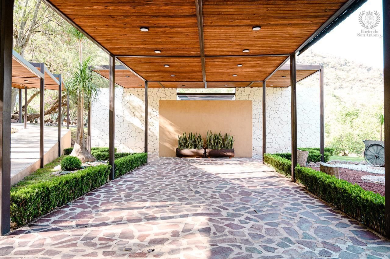 Pérgola de madera sobre andador de piedra